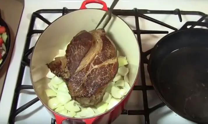 Ultimate Slow Cooker Beef Roast Recipe put on a bed of onions