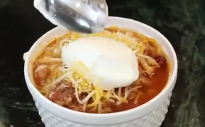 Slow Cooker Turkey Chili adding a spoon of sour cream